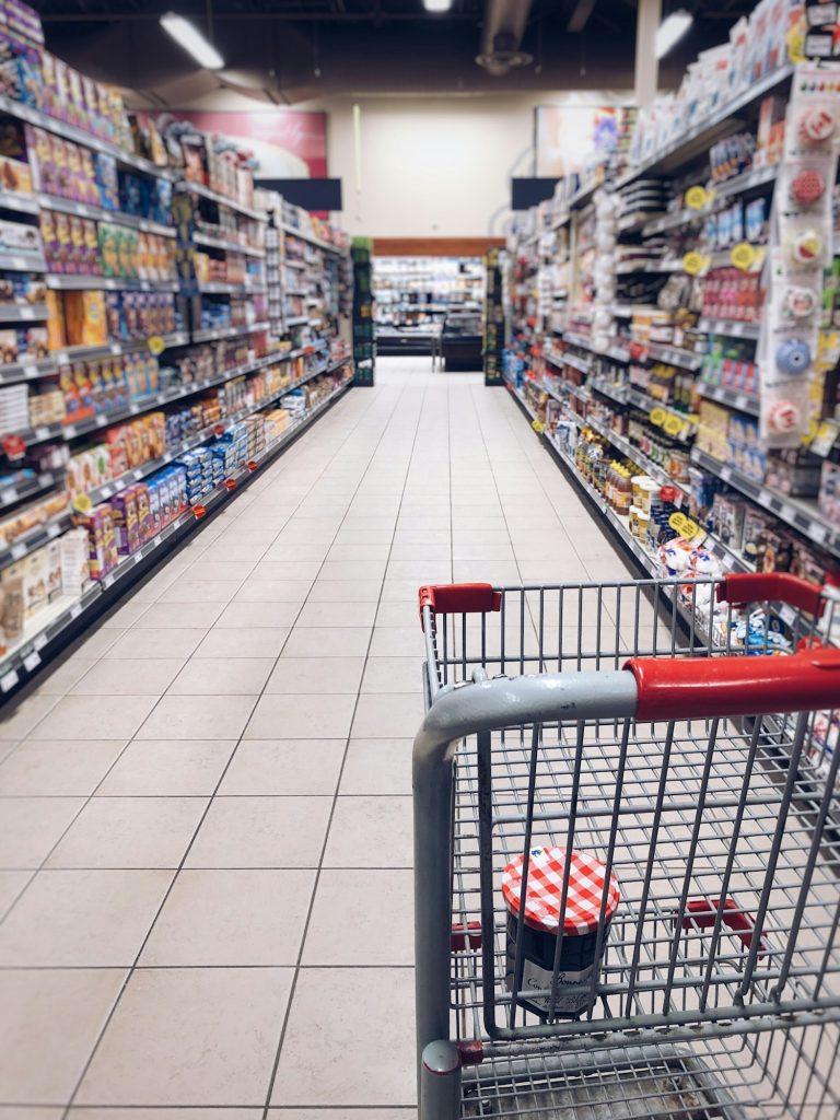 Grocery cart in the middle of a grocery store aisle