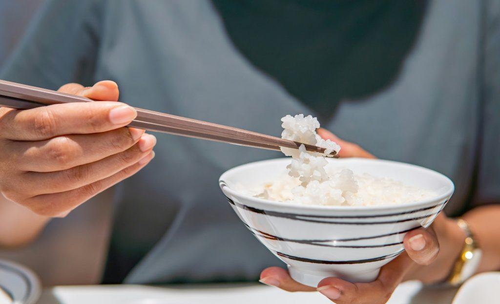 Asian woman eating rice at Japanese restaurant