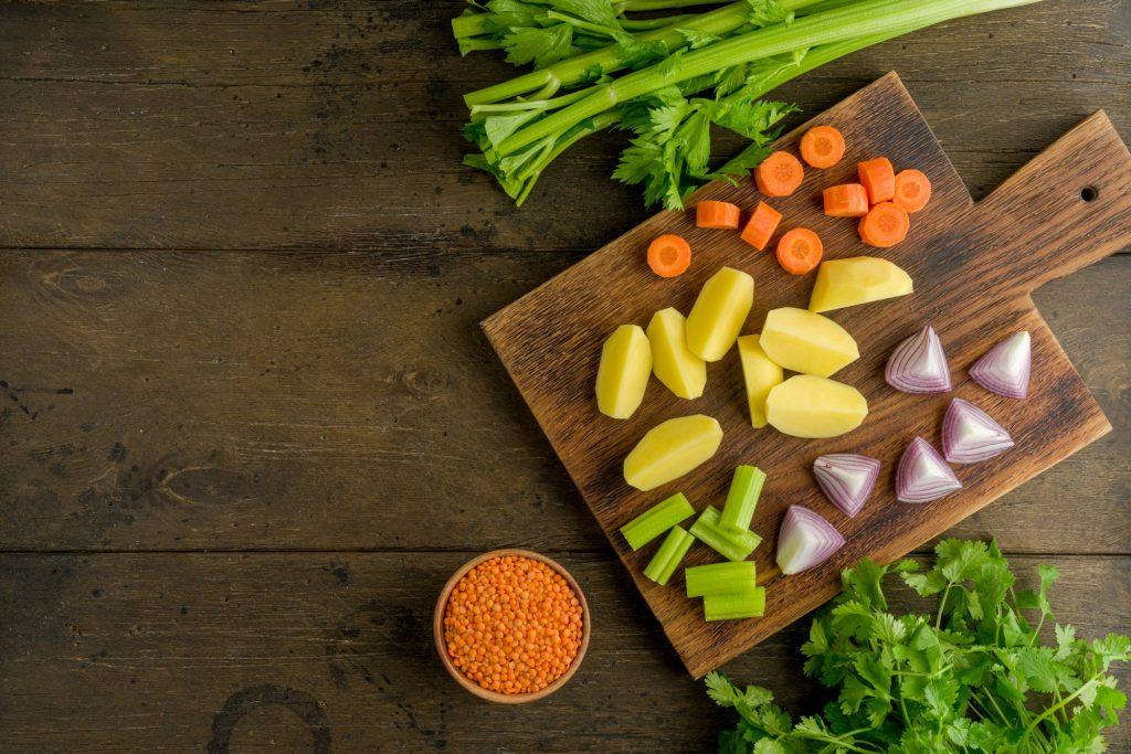 Horizontal of chopped vegetables on wooden board on dark wood background