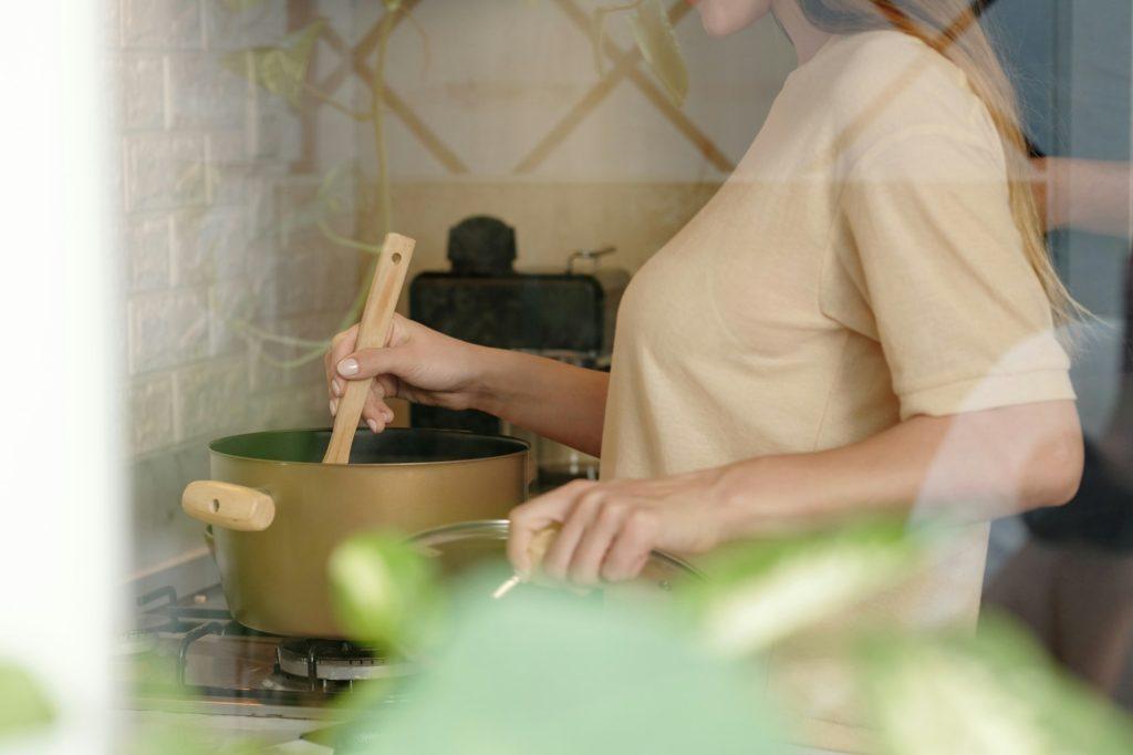 Woman Cooking Soup at Home